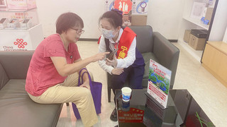 宁德联通志愿者帮助老年用户下载联通APP，指导使用方法。福建联通供图