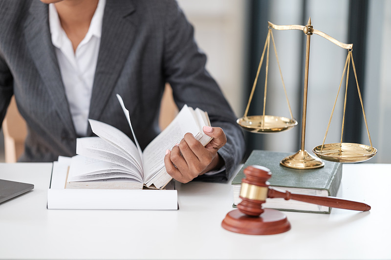 律师在办公室的办公桌旁看书的腰部特写图片下载