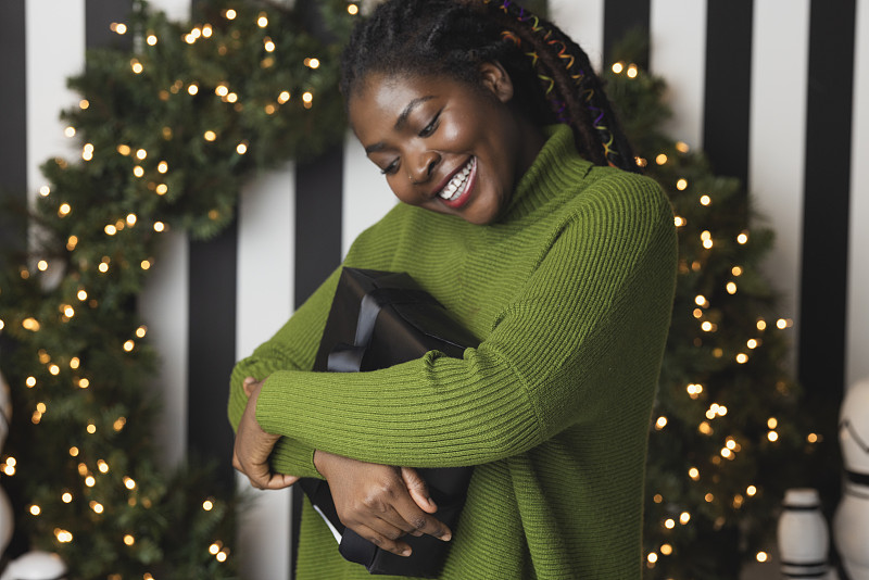 微笑的黑人妇女拿着圣诞礼物图片下载