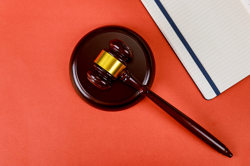 红色背景上的法槌和书籍的俯视角度照片图片下载