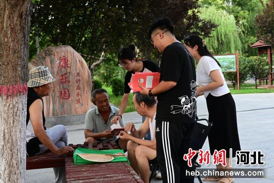 图为曲周县司法局工作人员正在为群众发放和讲解法律宣传手册。 胡海军 摄