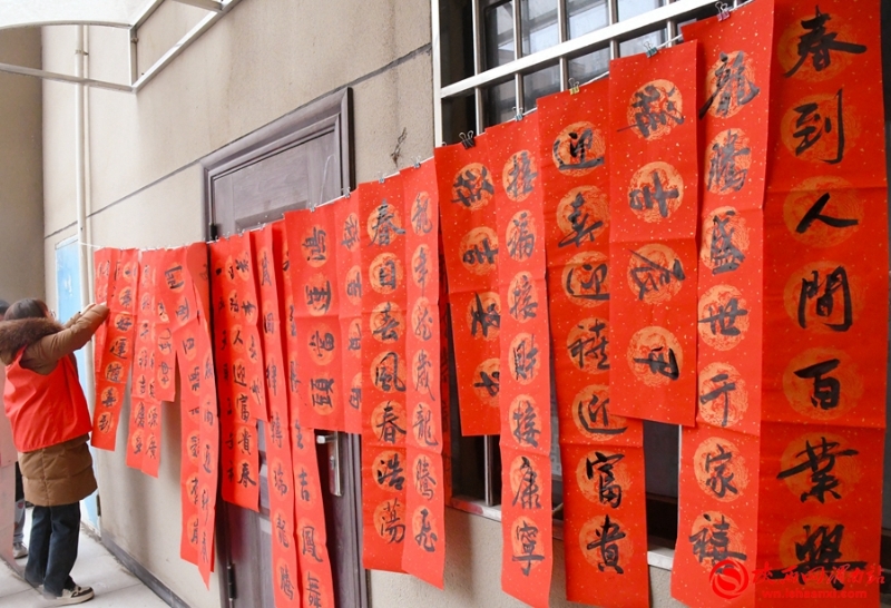火红的春联映红了社区群众的笑脸。记者 郝豆 摄