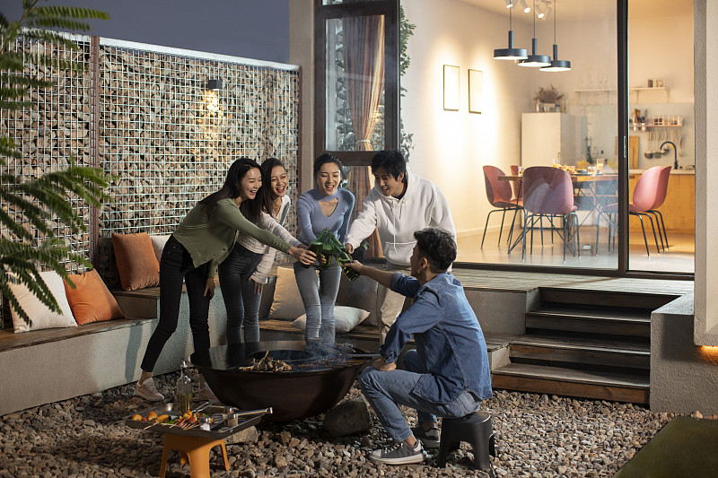 年轻朋友在庭院里烧烤聚餐图片下载