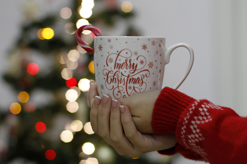 妇女手握圣诞杯的特写图片下载