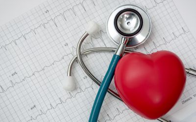 Red heart shown beside a stethoscope and EKG chart.