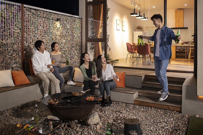 年轻朋友在庭院里烧烤聚餐图片下载