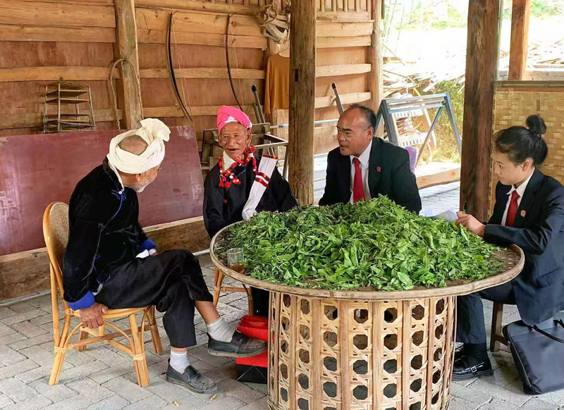 “托阿姆”调解室特邀调解员、德宏州中级人民法院法官杨云梁（右二）-走访德昂山寨群众。李雪萍摄