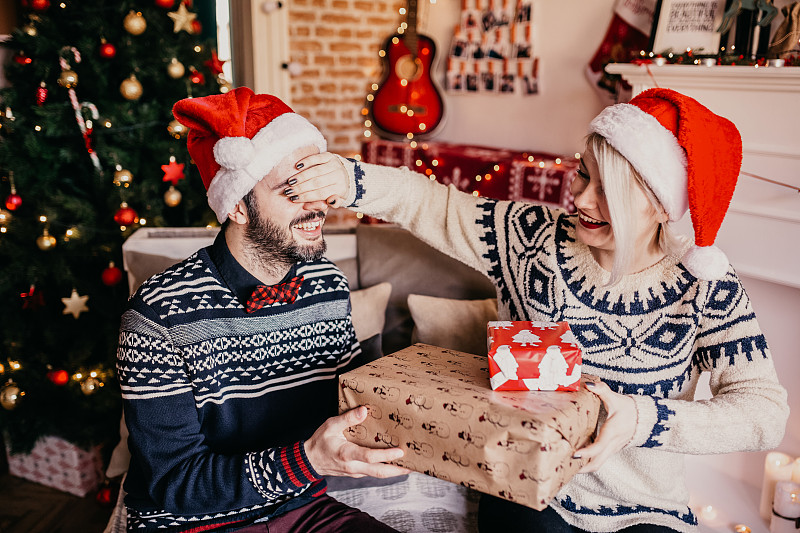一位女士送了一份圣诞礼物给她的男友一个惊喜。图片下载