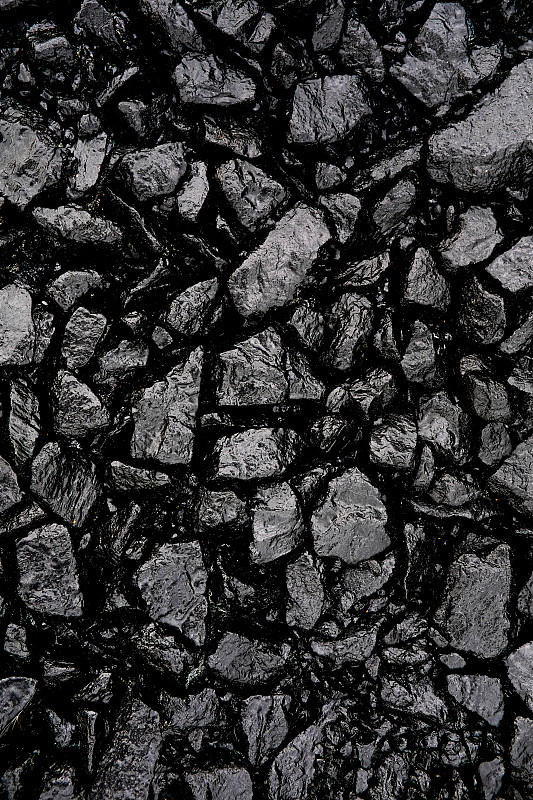 沥青浇筑筑路用的灰色或黑色碎石或碎石，浇筑沥青。沥青的制备和铺设。纹理背景。建筑行业。图片下载