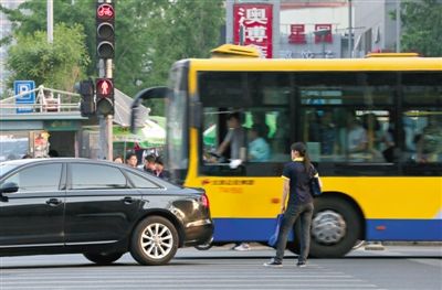 5月9日,朝阳路,一位闯红灯的市民被穿过路口的汽车“截停”在斑马线上。新京报记者 薛? 摄