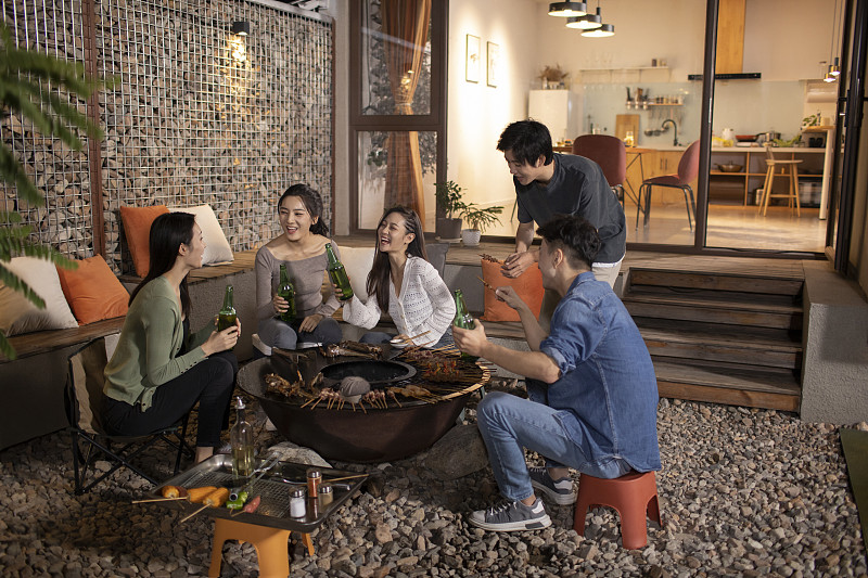 年轻朋友在庭院里烧烤聚餐图片下载